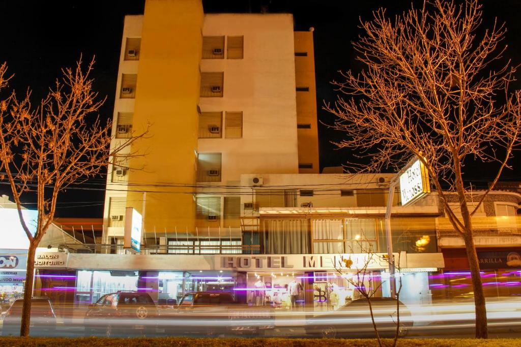 里奥夸尔托Hotel Menossi的一座建筑,在晚上,酒店前面