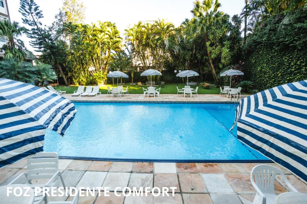 伊瓜苏福斯总统康福特茵酒店的一个带椅子和遮阳伞的游泳池