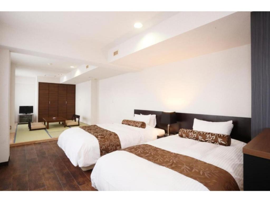仙北Tazawako Lake Resort & Onsen / Vacation STAY 78939的酒店客房配有两张床和一张书桌
