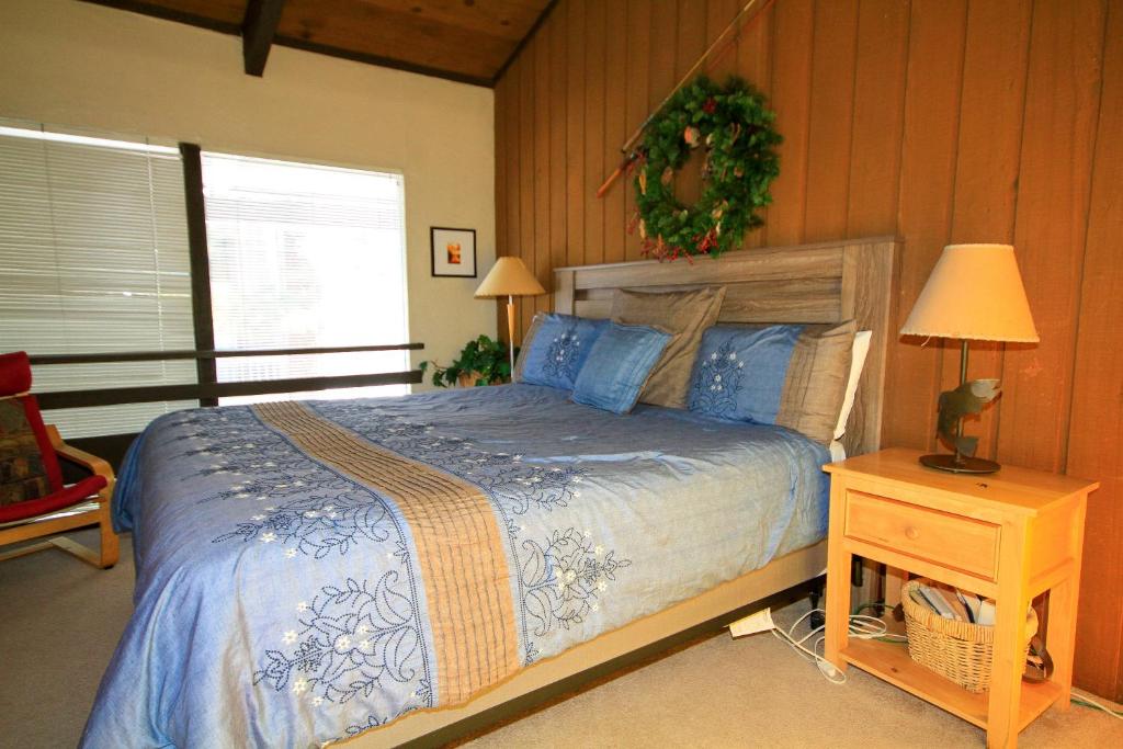 马姆莫斯湖Sierra Park Villas #16的一间卧室配有一张床和一张带台灯的桌子