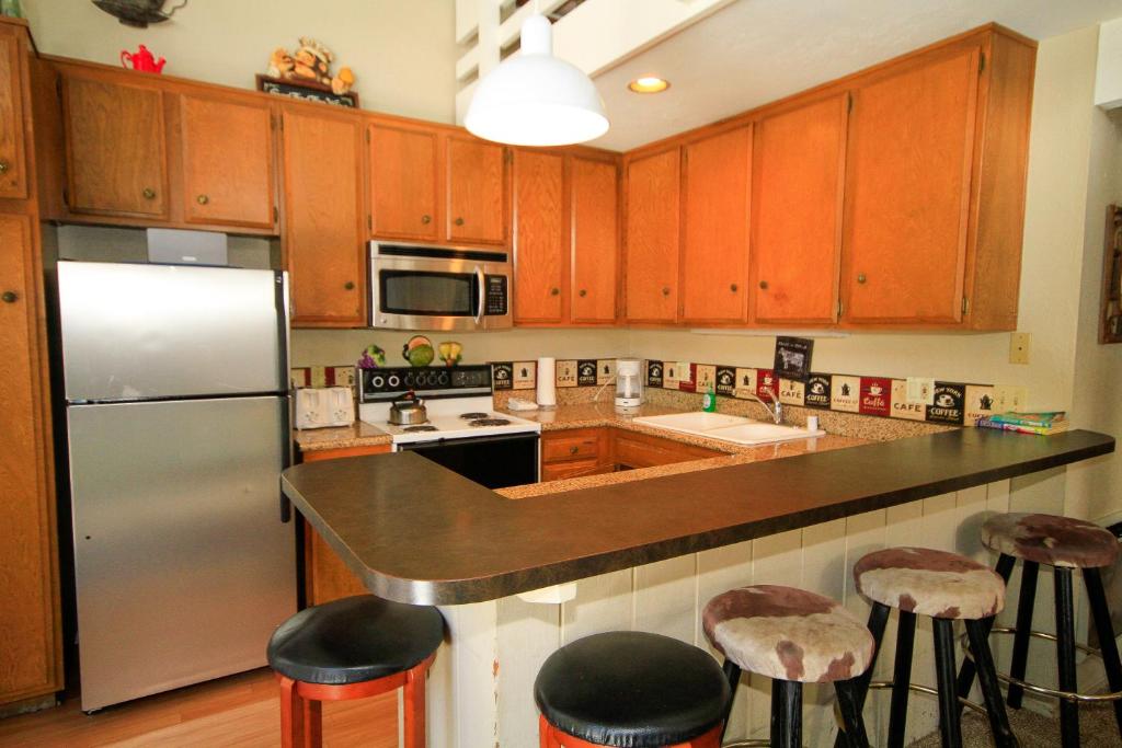 马姆莫斯湖Sierra Park Villas #89的厨房配有木制橱柜和不锈钢冰箱。