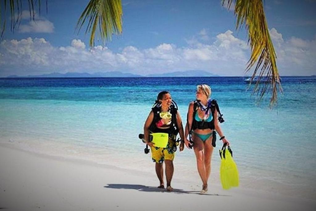 蓬塔杜欧鲁Devocean Eco Adventure Lodge的两名妇女在海滩上散步