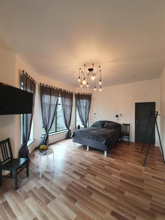 马鲁佩Valet Apartment的一间卧室配有一张床,铺有木地板
