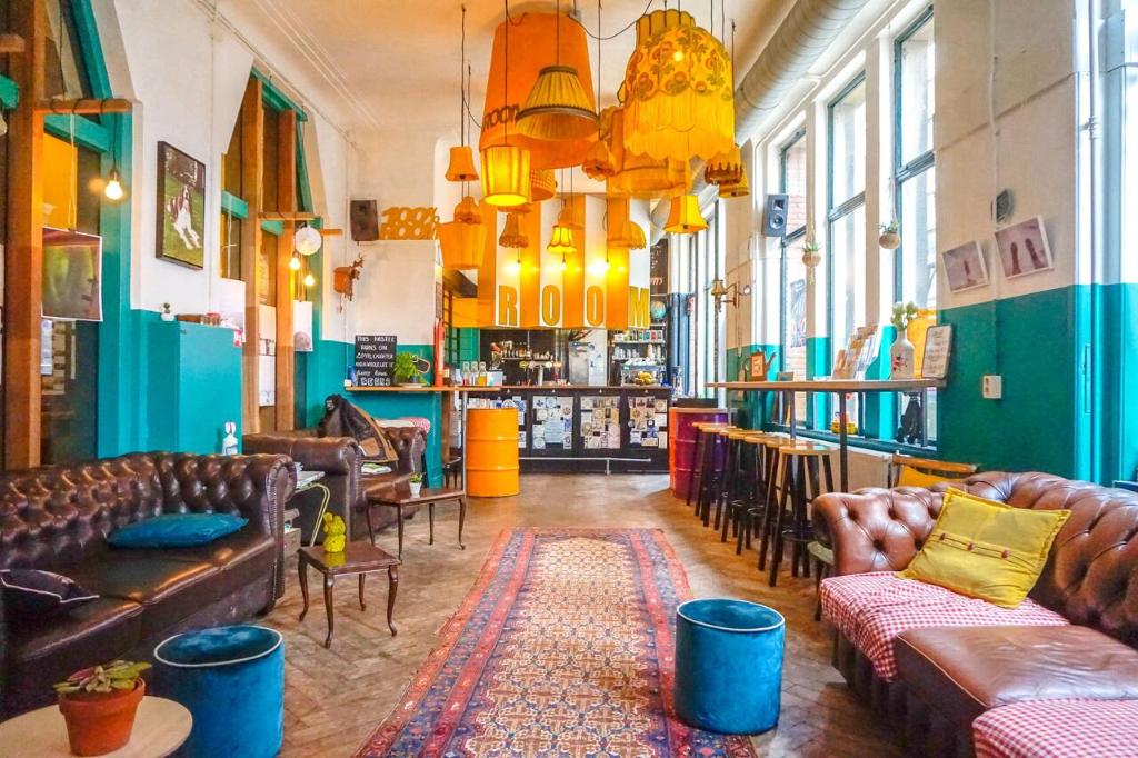 鹿特丹鹿特丹旅舍的带沙发和椅子的房间以及酒吧