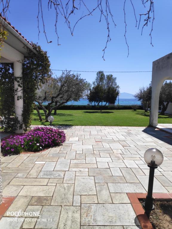 沃洛斯V.K.Seaside Villa的鲜花屋前的石头走道