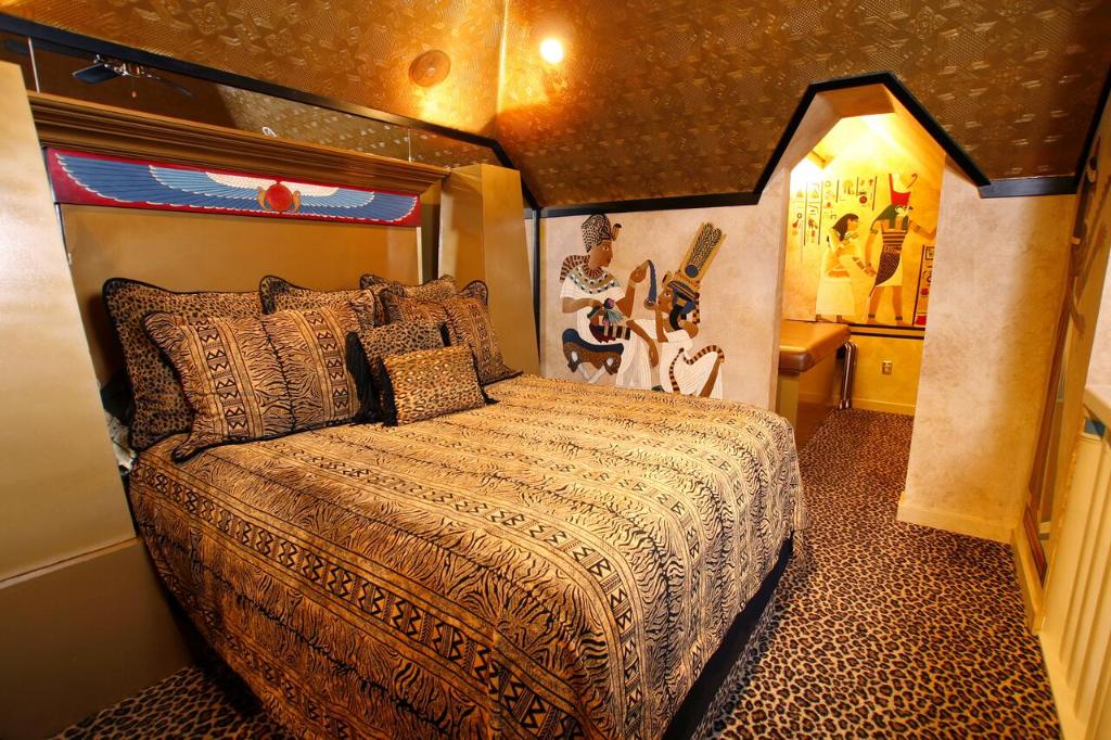 波卡特洛黑天鹅豪华主题客房酒店的一间小房间的卧室,配有一张床铺