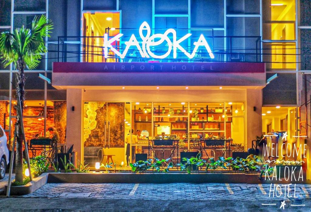 Labu SumbawaKaloka Airport Hotel的大楼一侧有 ⁇ 虹灯标志的餐厅