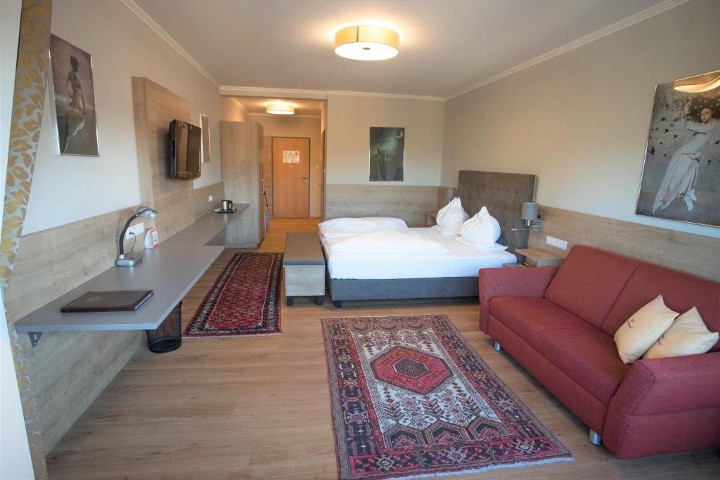 格拉茨德尔马里恩霍夫贾尼酒店的酒店客房,配有一张床和一张红色的沙发