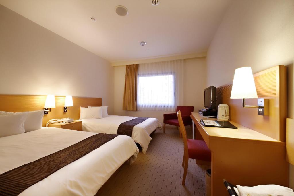成田成田沃卡酒店的酒店客房设有两张床和电视。