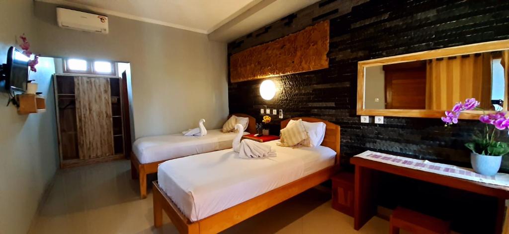 普卢坎The point surfcamp Bali的一间卧室设有两张床、一张桌子和一个窗口。