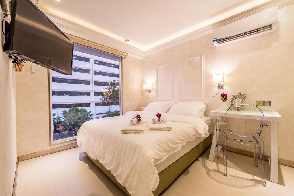 哥打京那巴鲁CJ Residence - Opposite Public Bank Centre Point的一间卧室设有一张带电视和窗户的床。