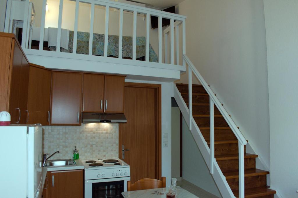 罗希姆诺Preveli Apartments的厨房设有通往阁楼的楼梯