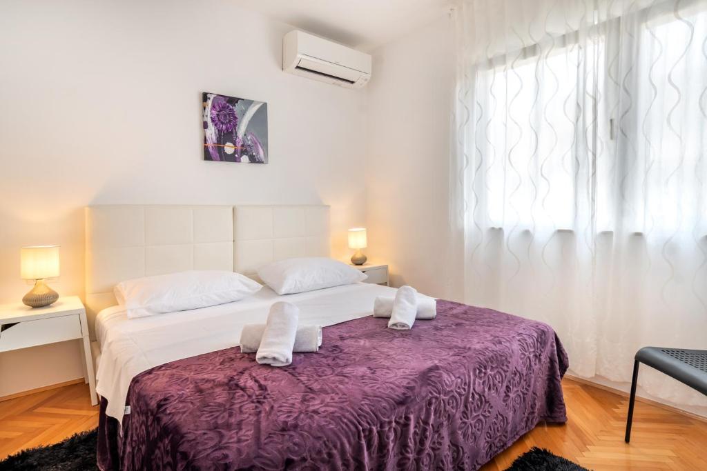 斯普利特Rooms&Apartments Zelux的一间卧室配有一张大床和紫色毯子