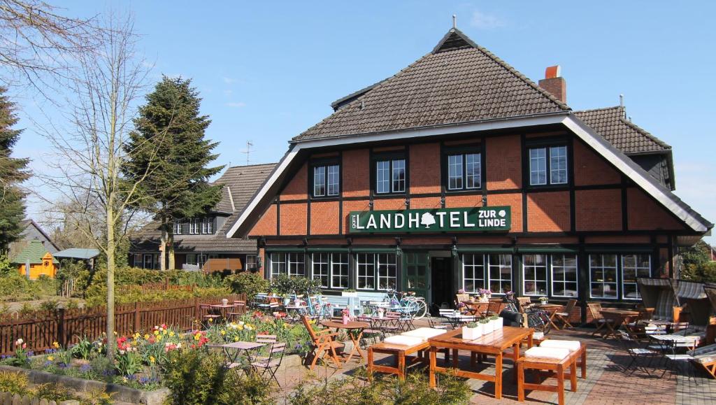 拉特考Landhotel garni zur Linde的前面设有桌椅的建筑