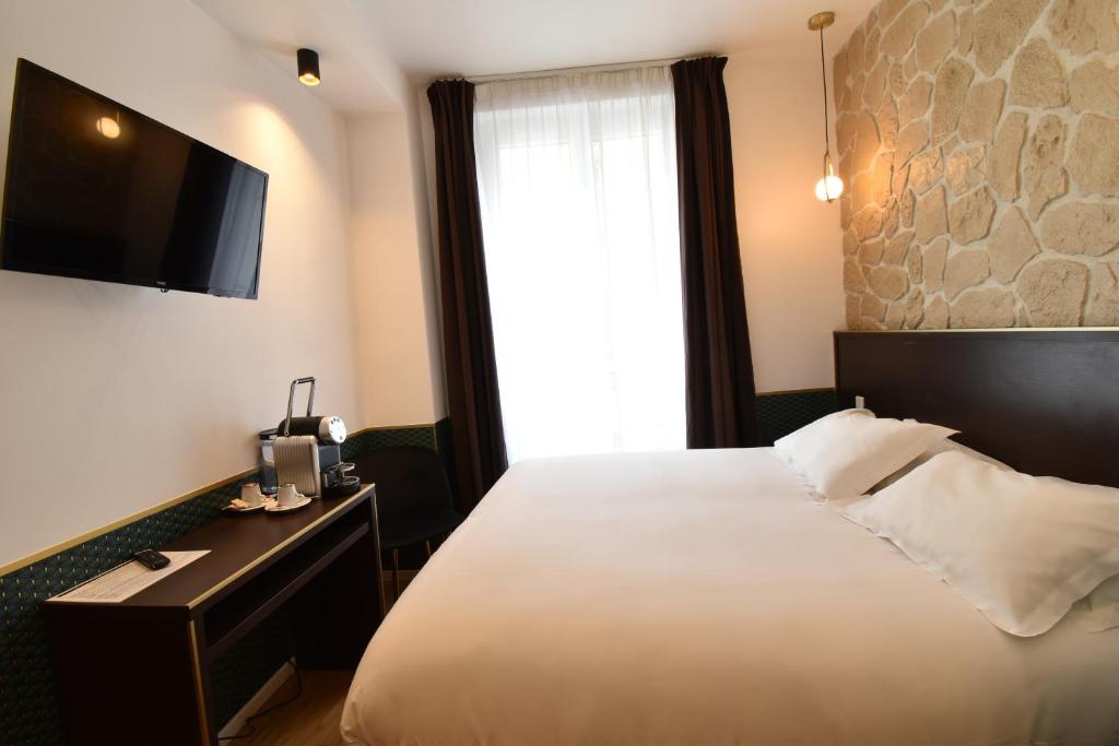 巴黎宝纳努维勒酒店的酒店客房,配有床和电视
