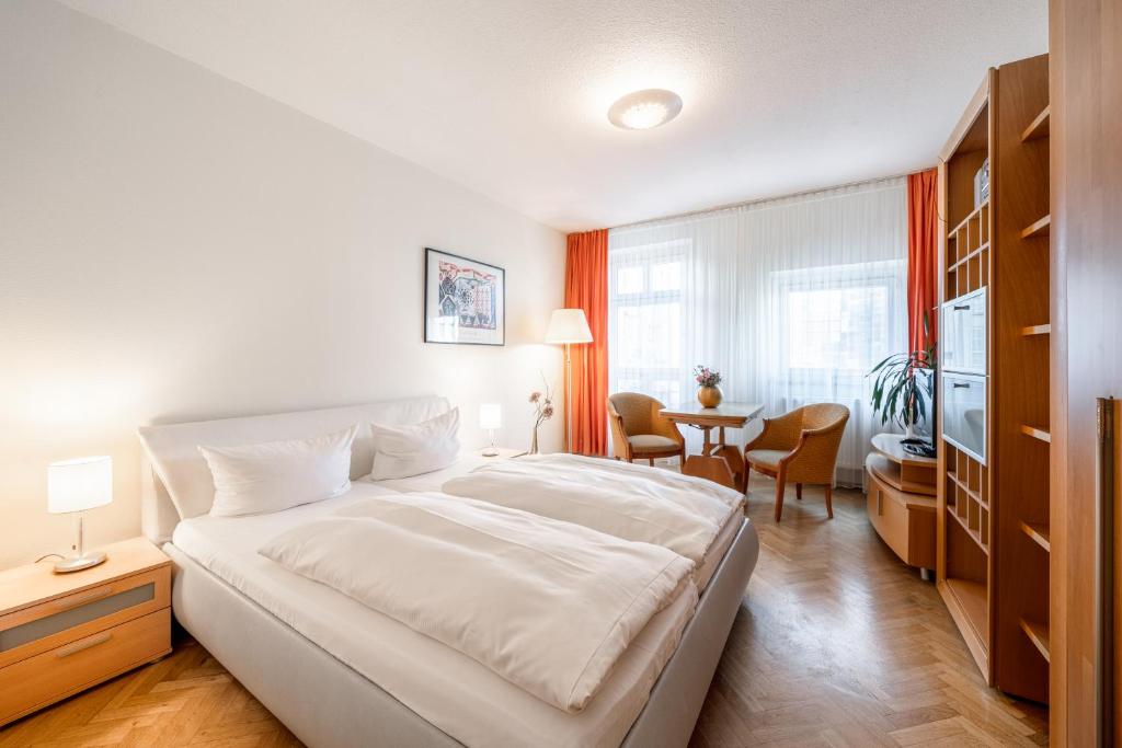 德累斯顿Aparthotel Münzgasse An der Frauenkirche的卧室配有一张白色的大床和一张桌子