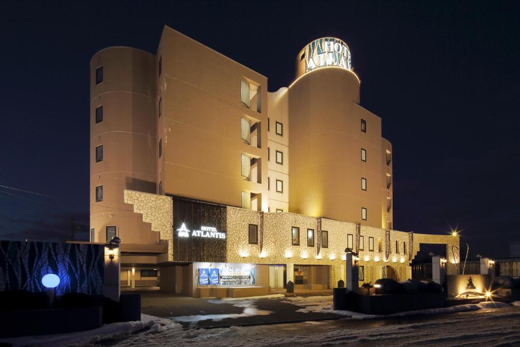 小樽HOTEL ATLANTIS Otaru(Adult Only)的一座在晚上设有钟楼的大型建筑