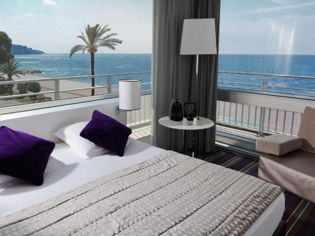 尼斯尼斯英国大道美居酒店的酒店客房设有一张床,享有海景。