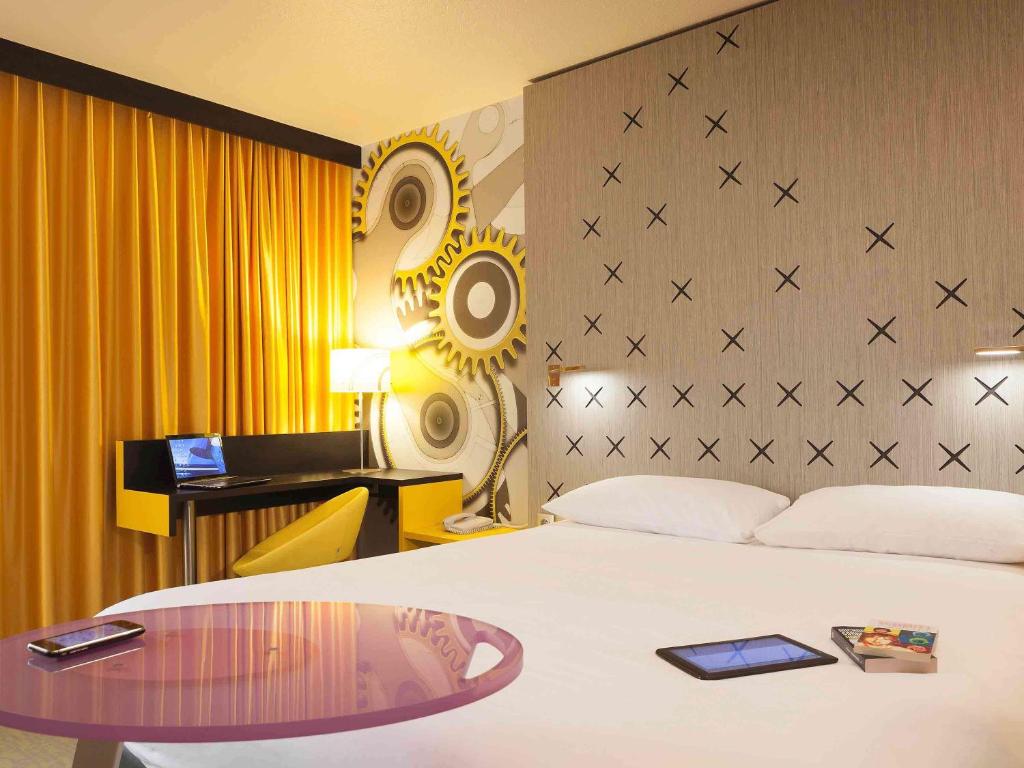 贝桑松贝桑松诺富特酒店的酒店客房配有一张带桌子和书桌的床。