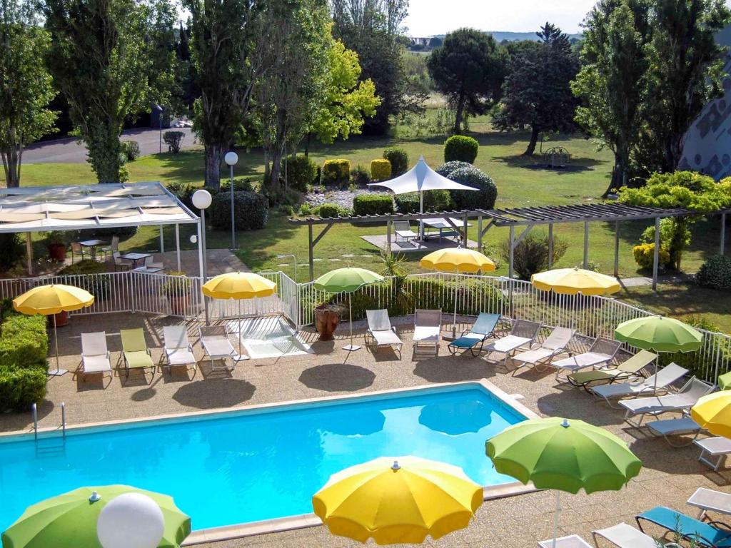 维特罗勒马赛机场宜必思尚品酒店的享有带遮阳伞和椅子的游泳池的顶部景致