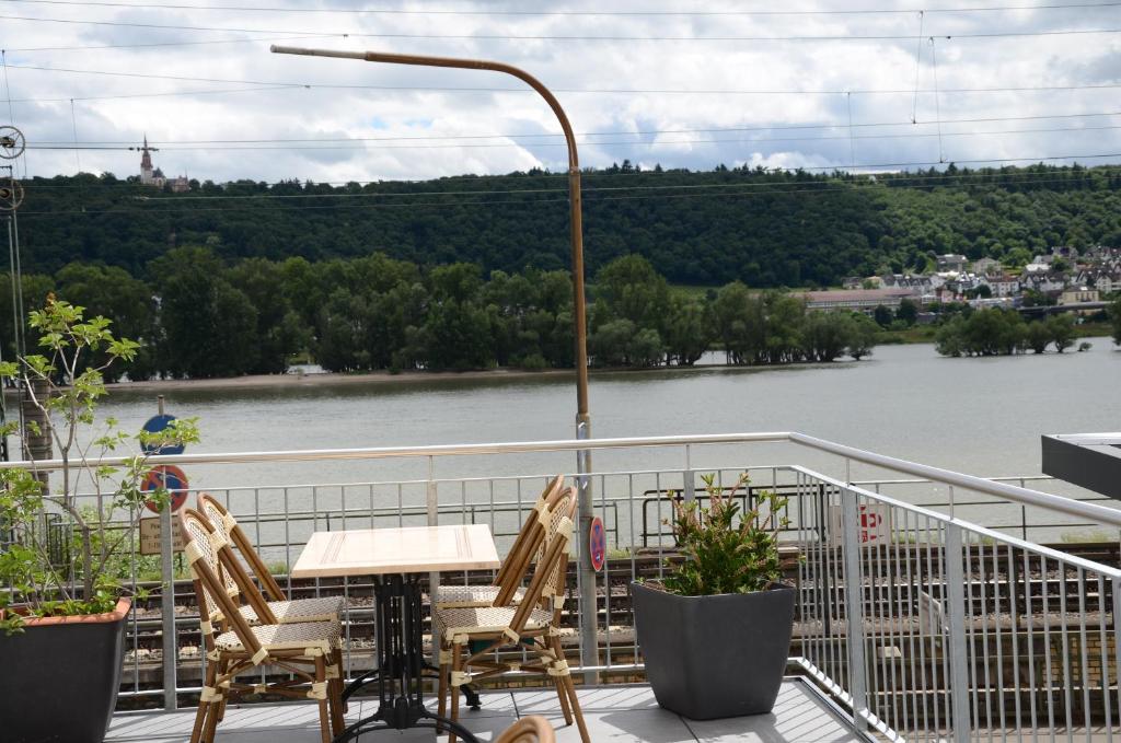 吕德斯海姆莱因斯坦酒店的河景阳台配有桌椅
