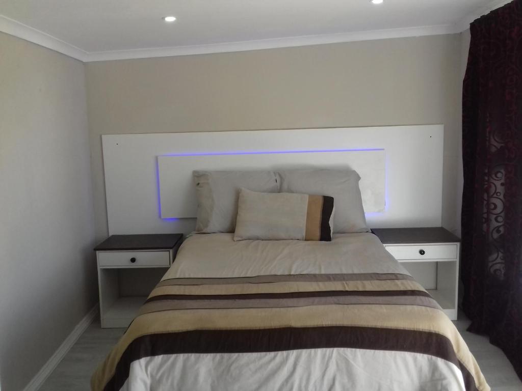 东伦敦High view accommodation的一间卧室,配有带2个床头柜的床