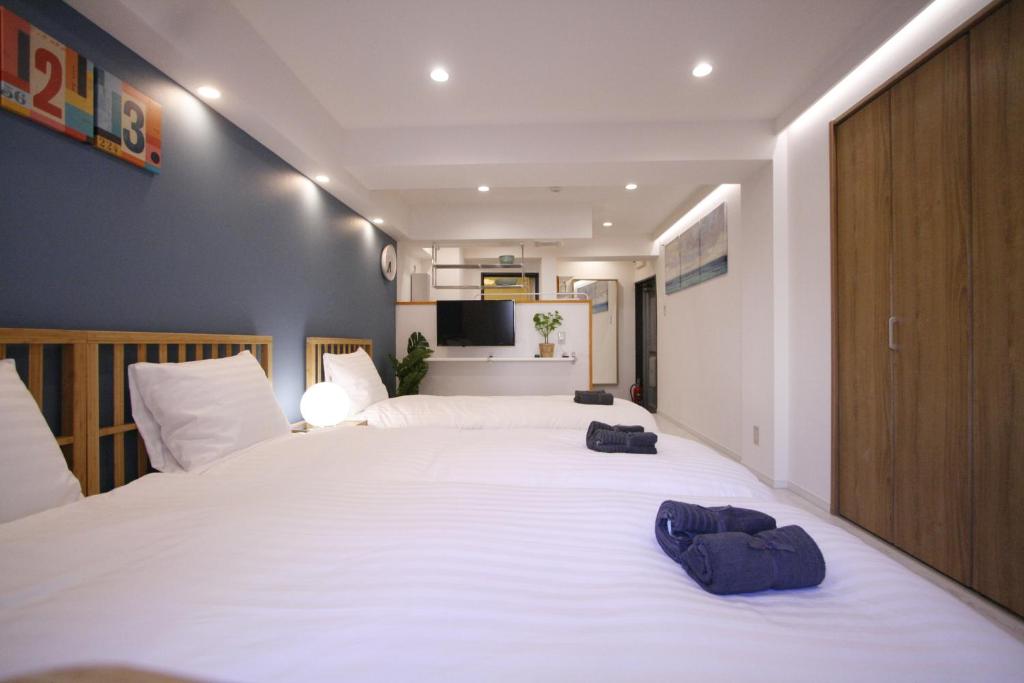 东京STAY ARI Kabukicho的卧室配有一张白色大床和两条毛巾