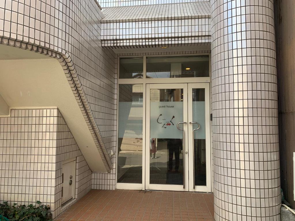 佐渡市Guesthouse Zink的玻璃门进入大楼的入口