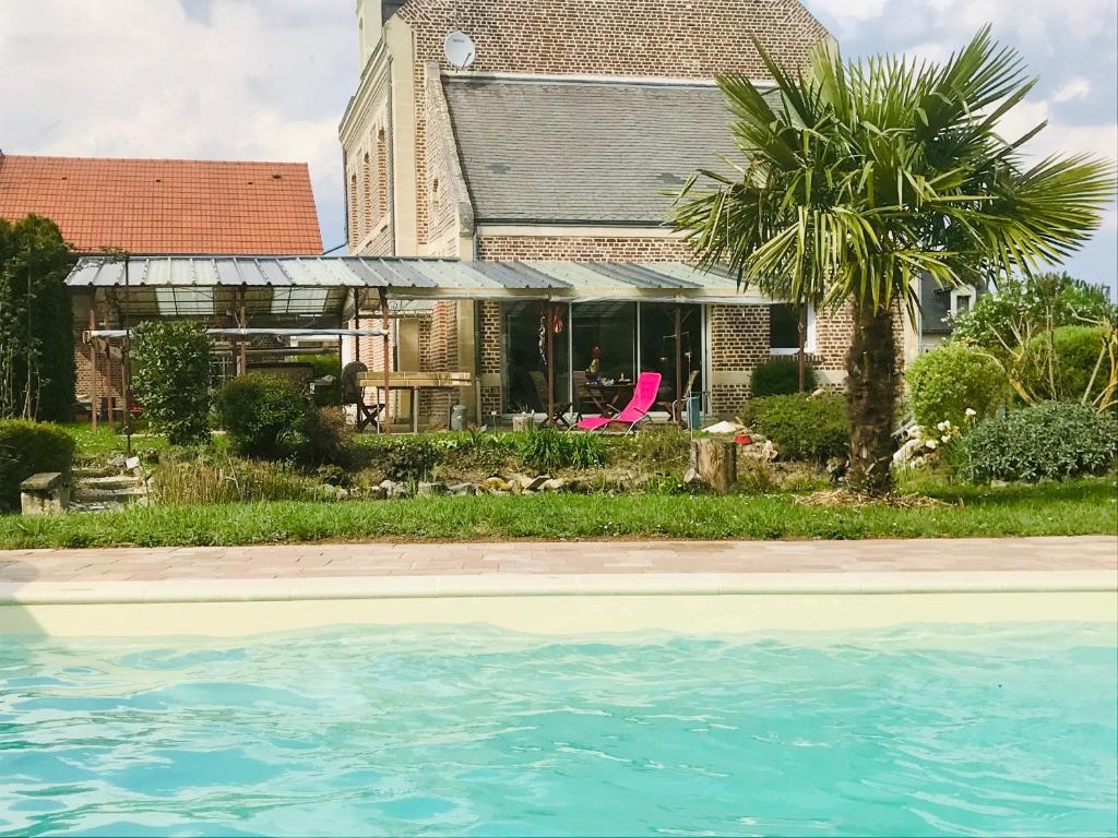 鲁瓦Les 3 Tilleuls的棕榈树和游泳池的房子
