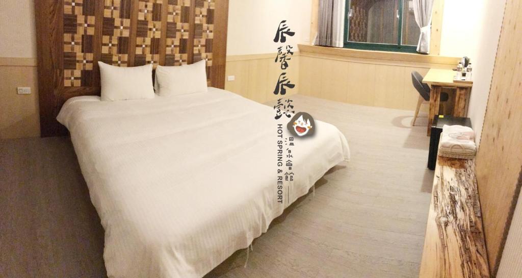 礁溪沐馨溫泉民宿的一间卧室配有一张大床,上面写着