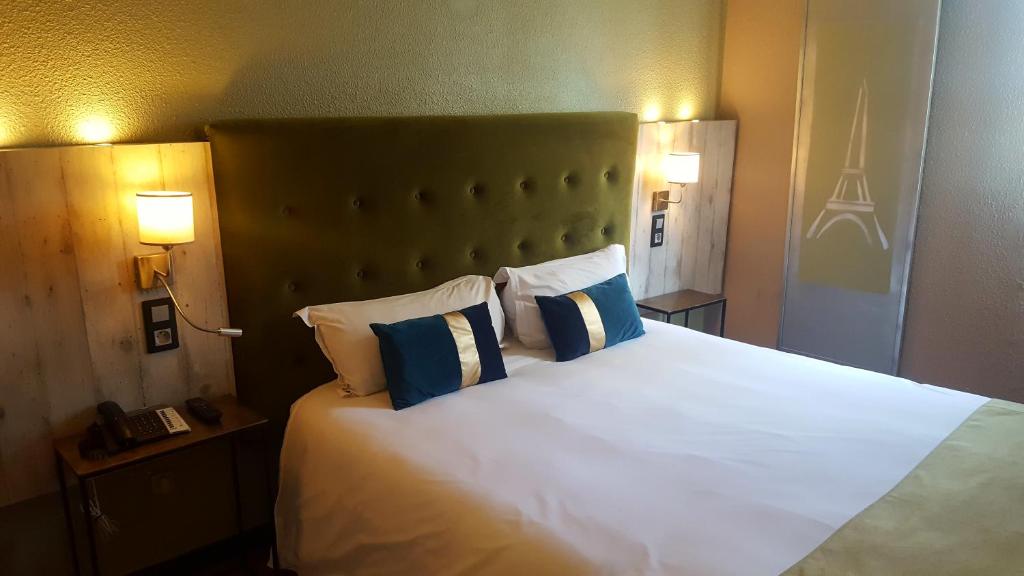 克雷泰伊Euro Hôtel Paris Créteil的卧室配有白色大床和蓝色及白色枕头