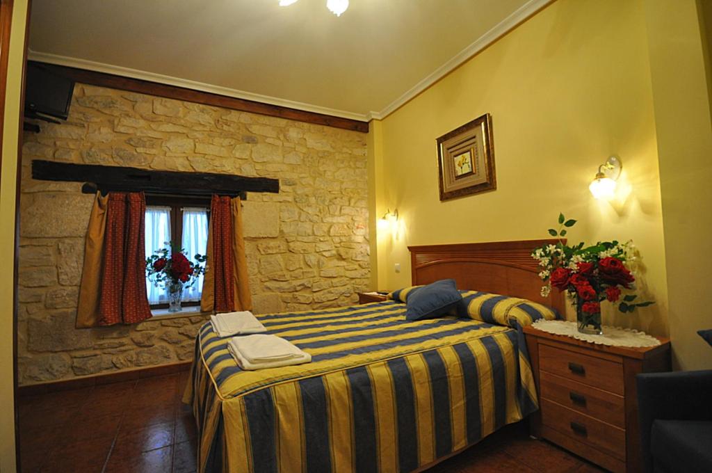 Cigüenzahotel rural anamari的一间卧室设有一张床和石墙