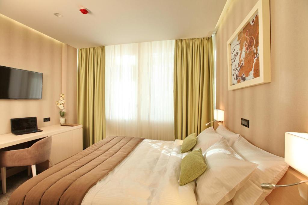 贝尔格莱德Hotel Argo的一间卧室配有一张床、一张书桌和一台电视
