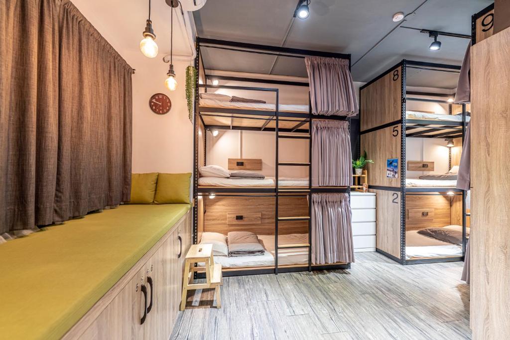 贡寮欧夫寇斯冒险青旅的客房设有带绿色长凳的双层床。