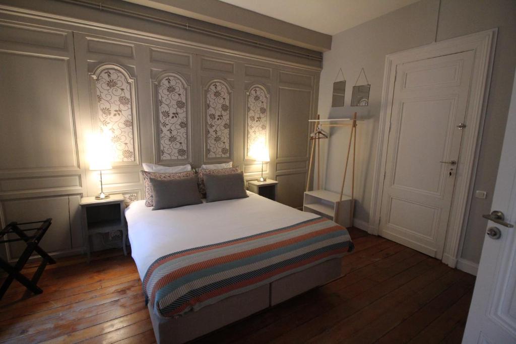 波尔多B&B L'Escapade Bordelaise的一间卧室配有一张大床和两盏灯