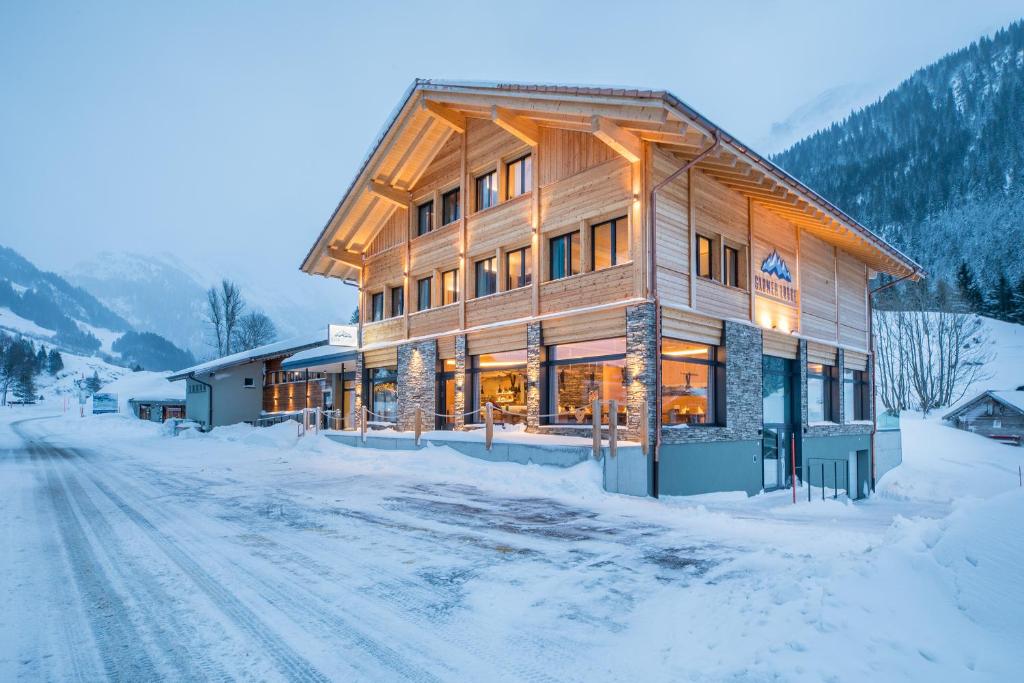 GadmenGadmer Lodge - dein Zuhause in den Bergen的一座大木结构建筑,位于雪覆盖的道路上