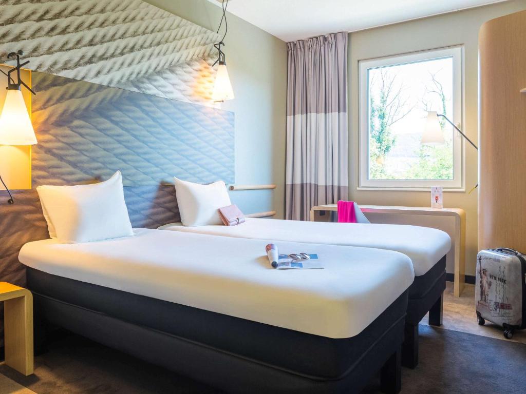 多维尔宜必思多维尔中心酒店的一间设有大床和窗户的酒店客房