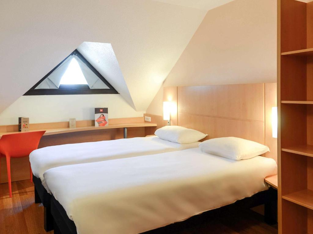 讷韦尔讷韦尔宜必思酒店的酒店客房设有两张床和窗户。
