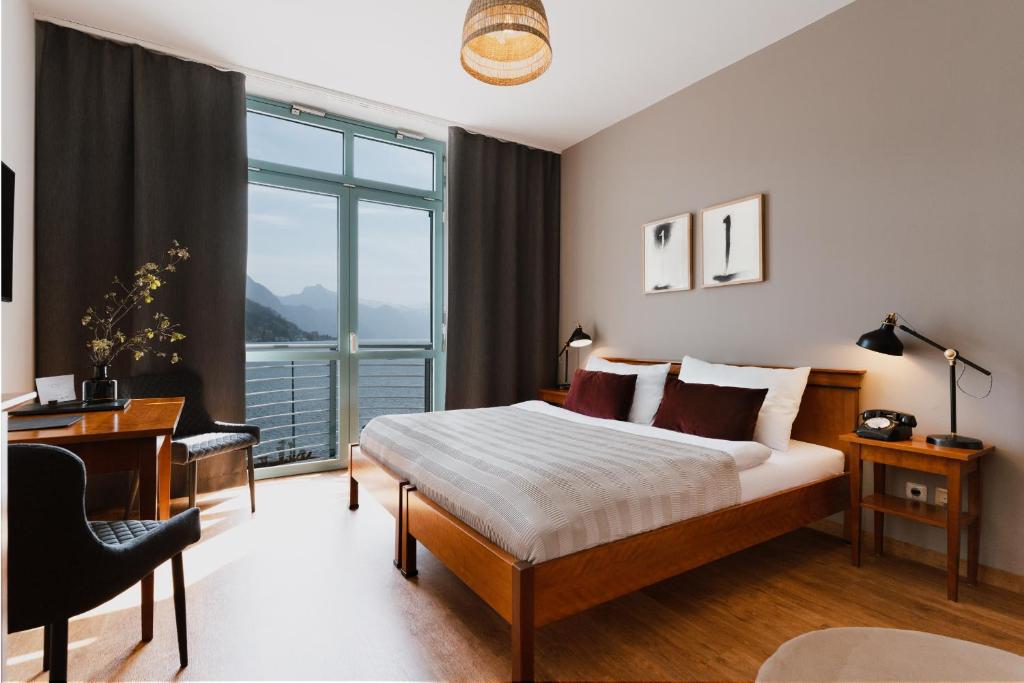 格蒙登Hotel Esplanade的一间卧室配有一张床、一张书桌和一个窗户。