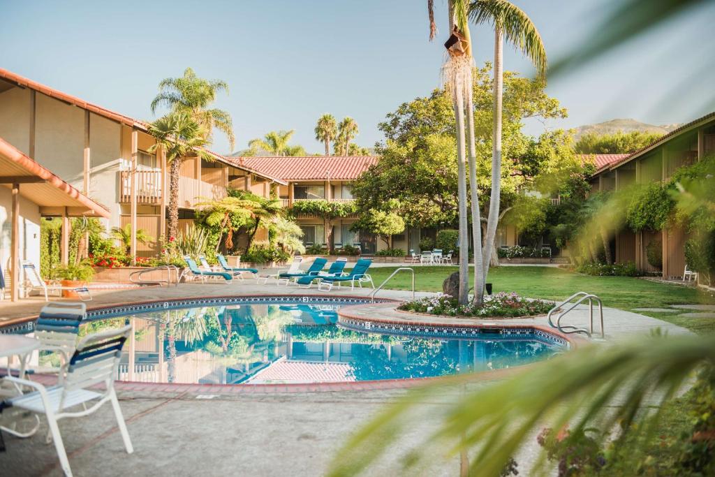 圣巴巴拉贝斯特韦斯特胡椒树酒店的一个带椅子和棕榈树的度假村游泳池