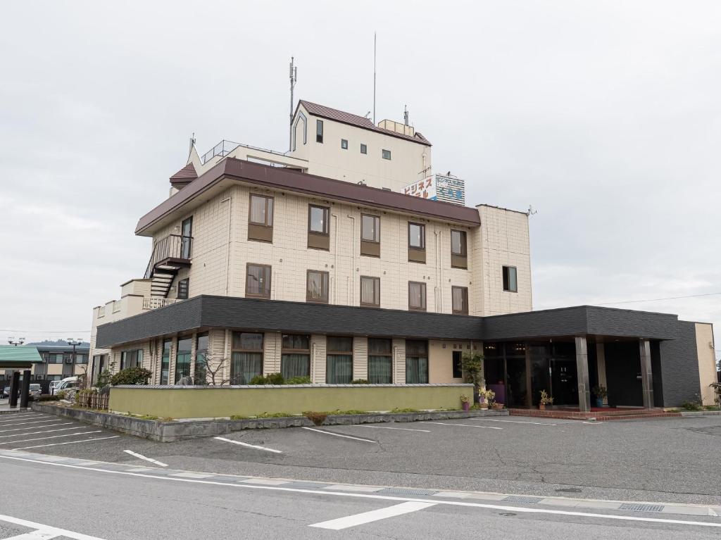 TakamiyaTabist Hotel Kurama Hikone的停车场角落的建筑物