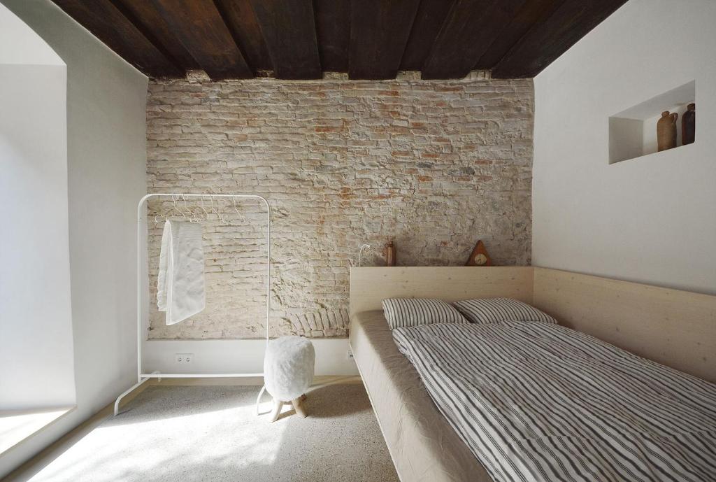 林茨HÜBSCHES APARTMENT im Herzen von Linz的一间卧室设有一张床和砖墙