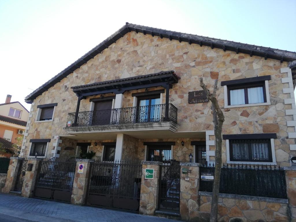 瓜达利斯-德拉谢拉Los Alisos Casa Rural的一座石头建筑,旁边设有阳台