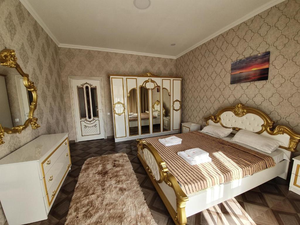 QabanbayИнжу Алаколь的一间卧室配有金色床和水槽