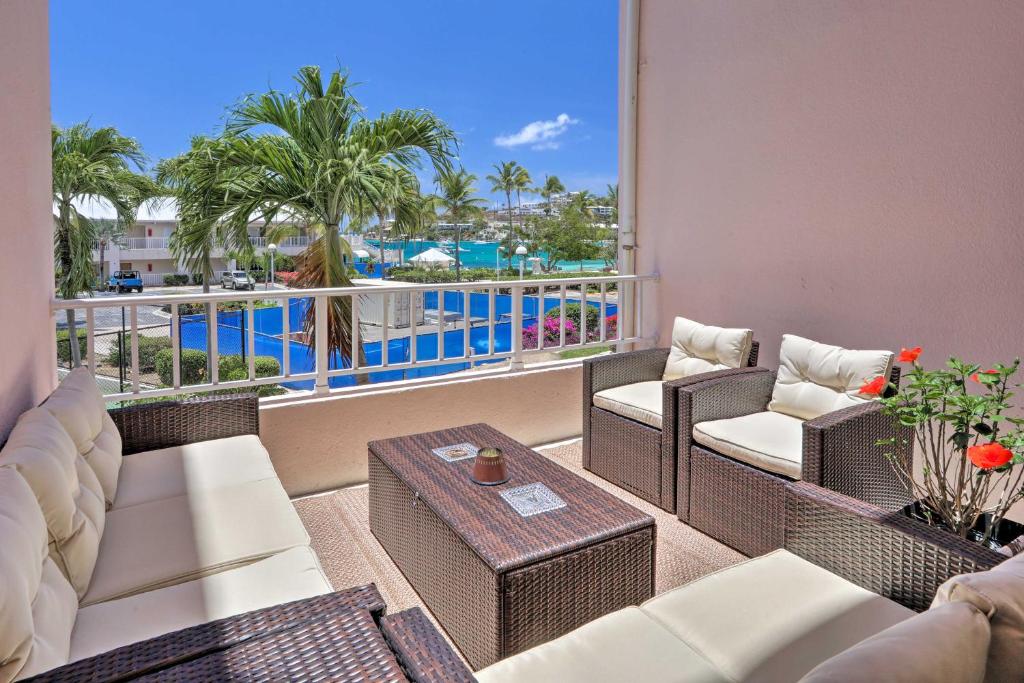 拿撒勒Tropical St Thomas Resort Getaway with Pool Access!的阳台配有桌椅,享有游泳池的景致。