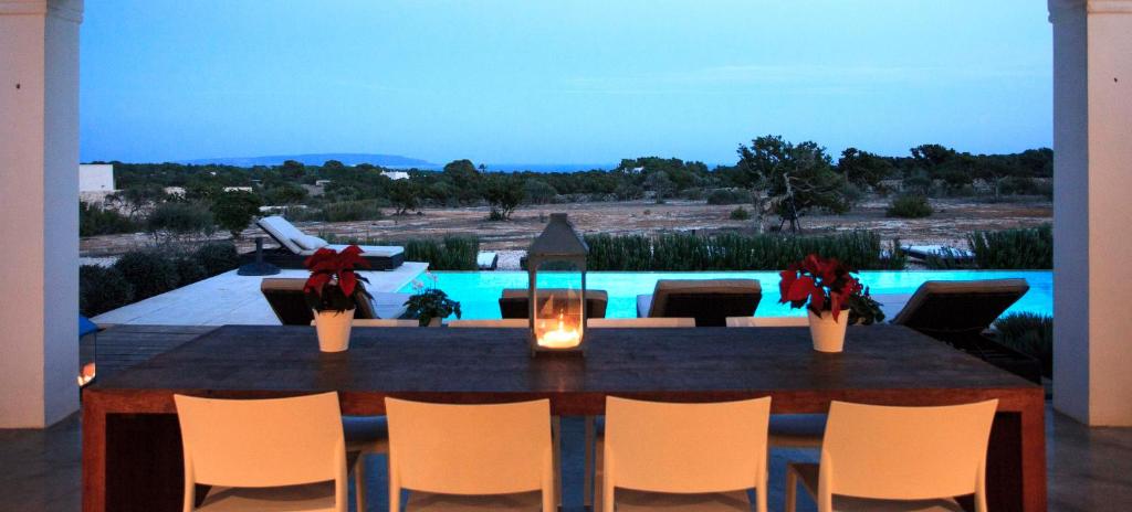 卡拉索纳Casa Santolina的享有泳池景致的餐桌和椅子