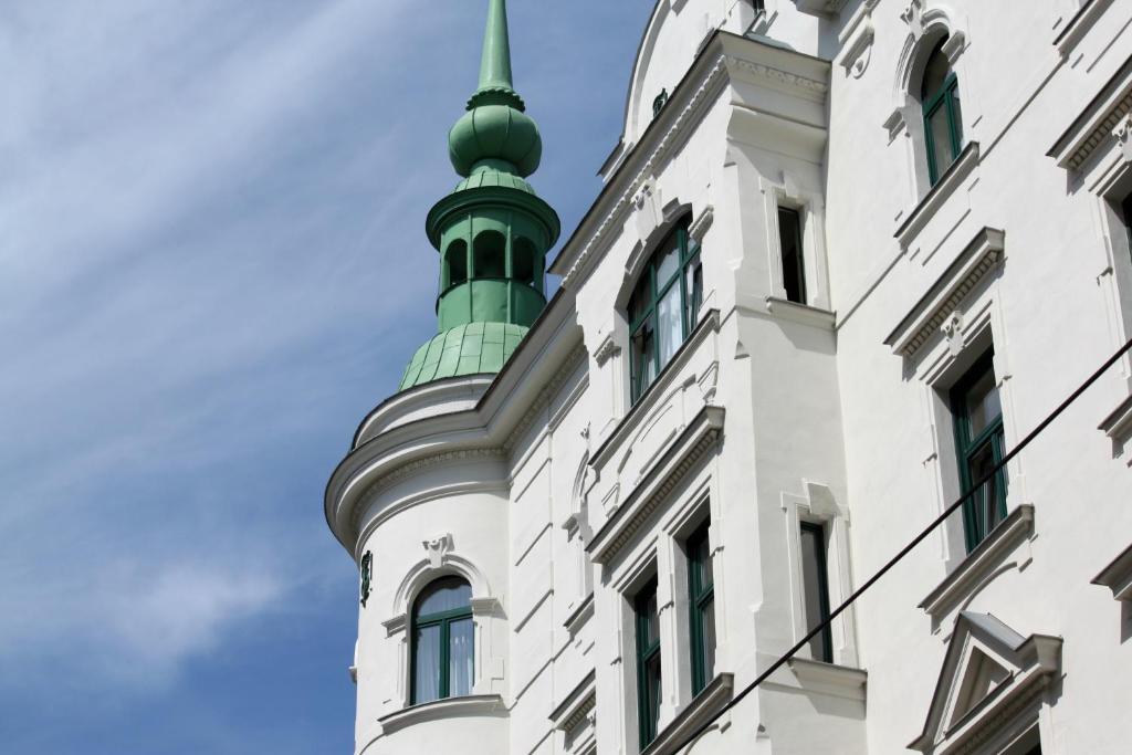 维也纳野趣膳食酒店的白色建筑上的绿色顶点