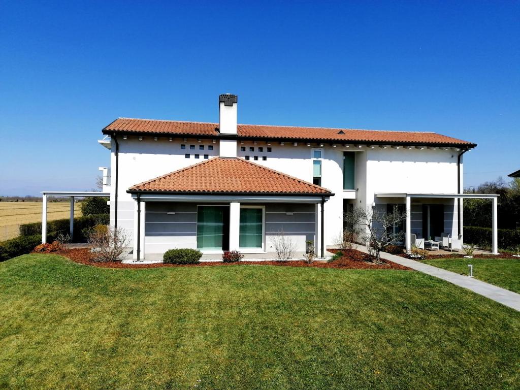 圣埃琳娜-迪西利亚Ca' Belvedere的前面有绿色草坪的白色房子