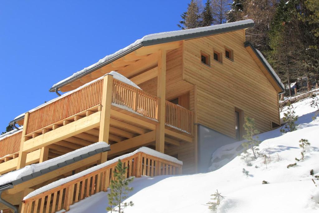 图拉彻霍赫Chalet Sunnseitn - auf der Turracher Höhe的雪地小木屋,带甲板