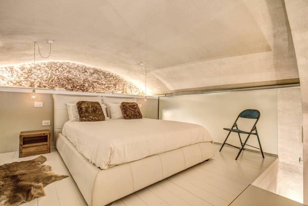 罗卡迪梅佐LOFT DI DESIGN ESCLUSIVO的一间卧室配有一张大床和一把椅子